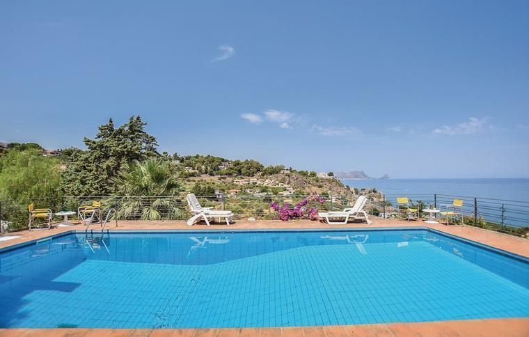 Utsikt från pool till ett boende på Sicilien